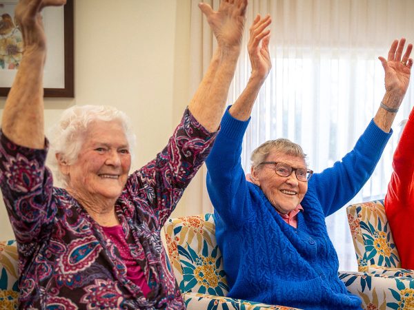 BAPTCARE AMBERLEA Residents doing arm chair stretches to the sku as part of physical activities