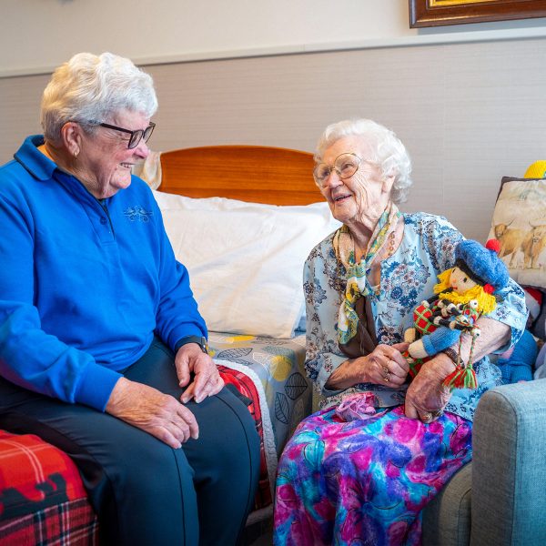 BAPTCARE COASTHAVEN Resident in her room with her daughter talking about her favourite colourful doll