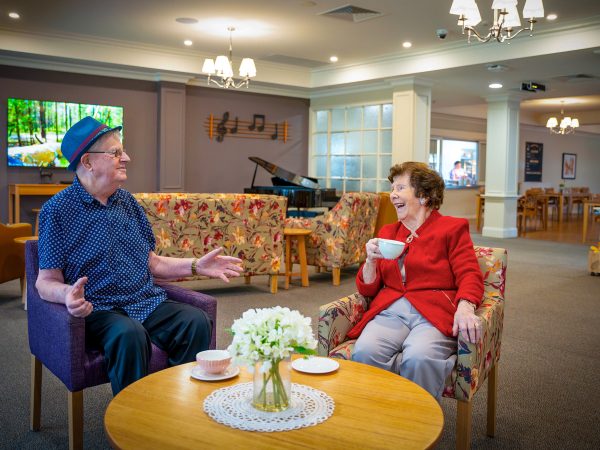 BAPTCARE HERITAGE MANOR Resident friends having a cup a tea and a joke together in the lounge area