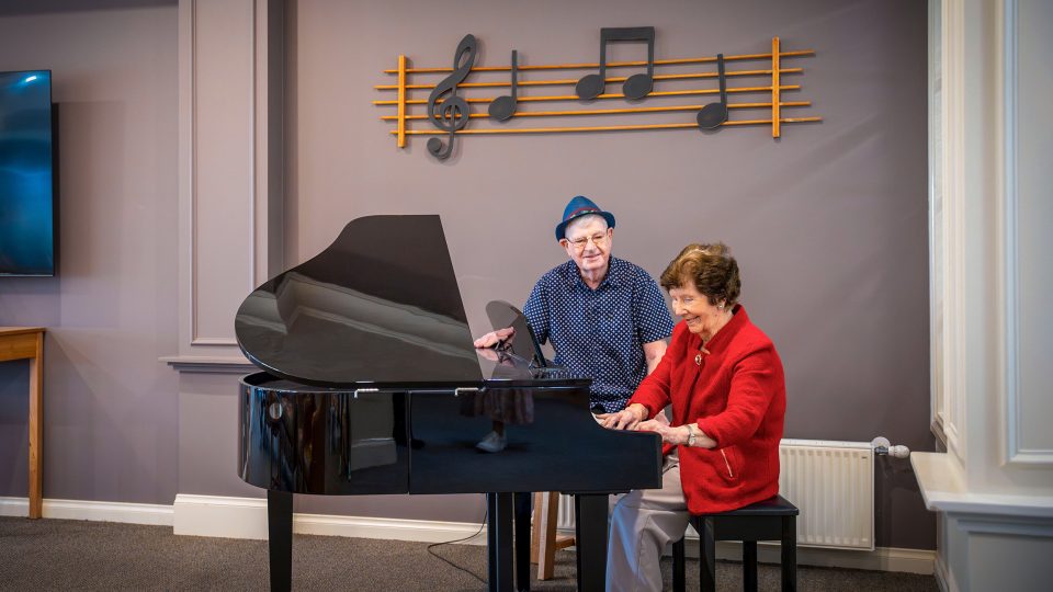 BAPTCARE HERITAGE MANOR Resident friends and musicians at the grand piano in the lounge area