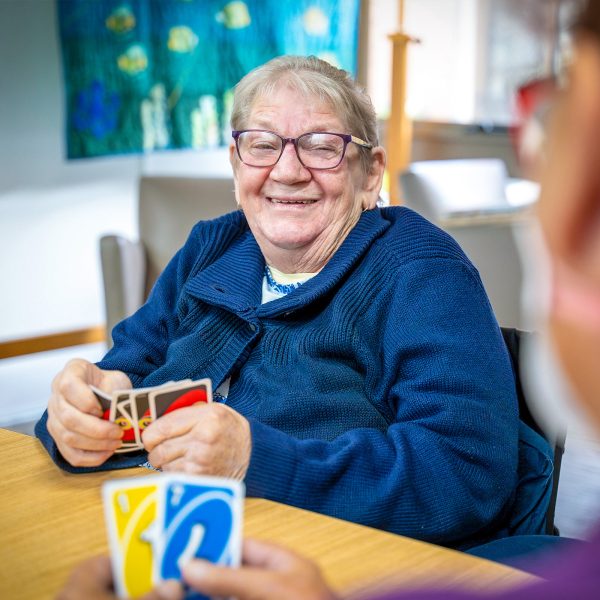 BAPTCARE NORTHAVEN Resident portrait all smiles while playing cards