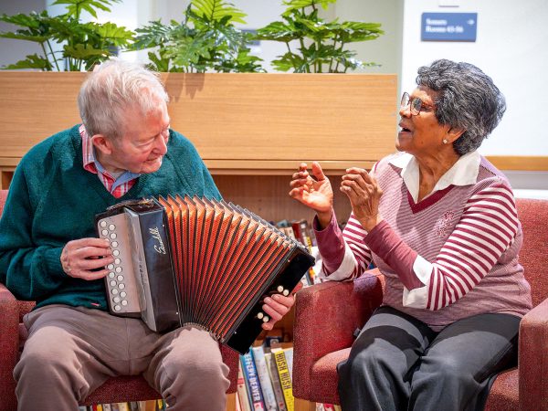 BAPTCARE PENINSULA VIEW resident playing accordian for another resident