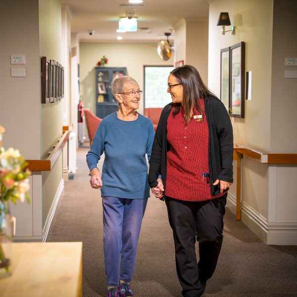 BAPTCARE PENINSULA VIEW resident and staff member taking a walk in the corridor