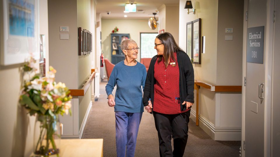 BAPTCARE PENINSULA VIEW resident and staff member taking a walk in the corridor