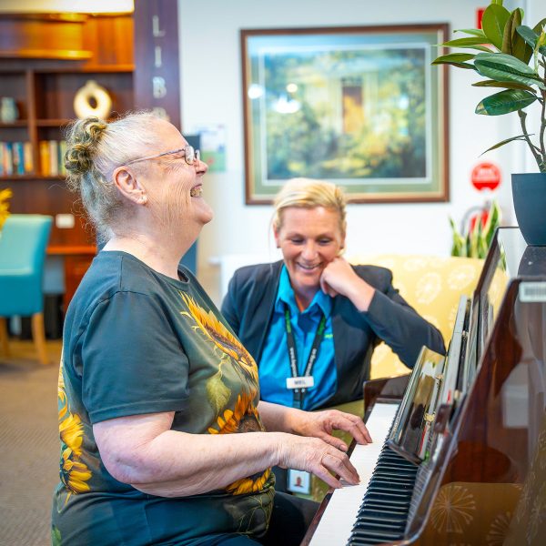 BAPTCARE ST HILARYS resident playing piano while staff member listens