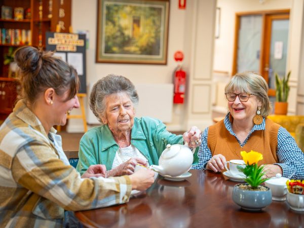 BAPTCARE ST HILARYS Residential Care resident and her daughters enjoying tea and a laugh