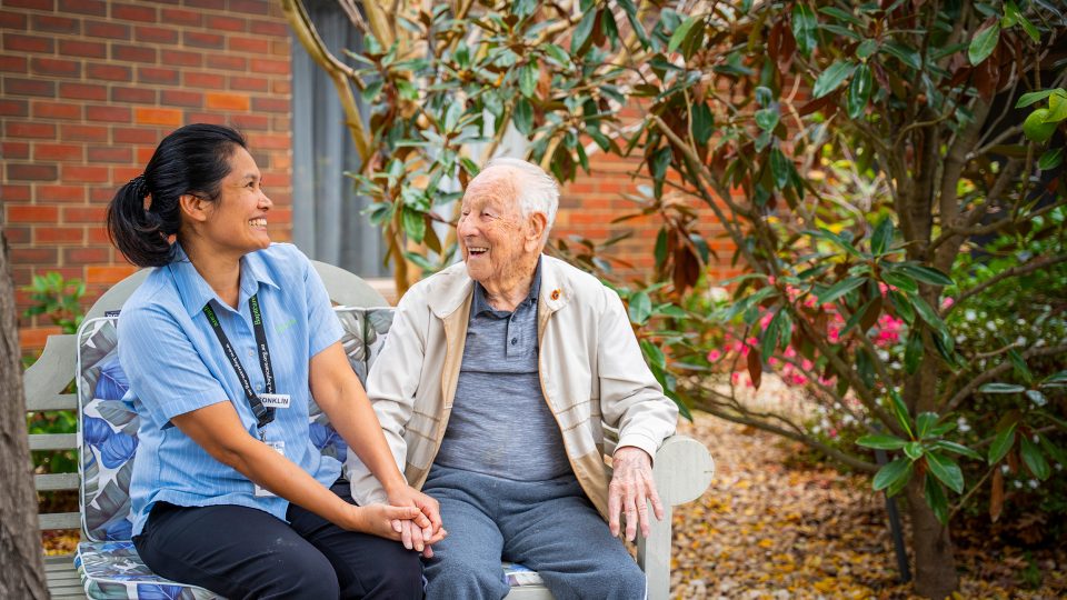 BAPTCARE ST HILARYS Residential Care resident and staff member outside enjoying the garden and a chat