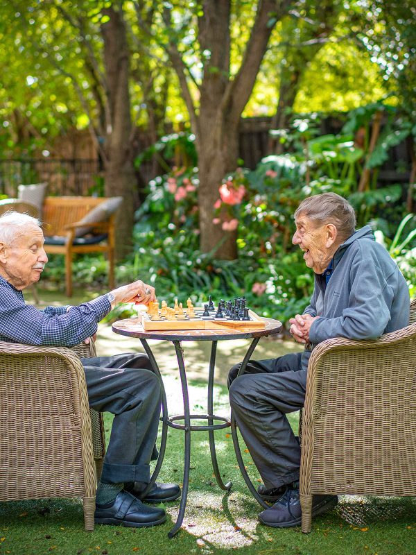 BAPTCARE WESTHAVEN two resident friends playing chess outside in the garden