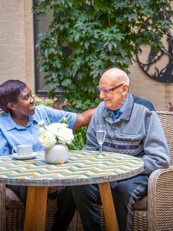 BAPTCARE Wyndham Lodge staff member pausing to sit and talk with a resident