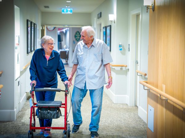 BAPTCARE Wyndham Lodge two resident friends walking and laughing in corridor