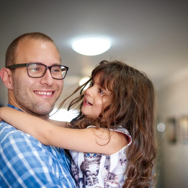 FAMILY COMMUNITY Young dad hugging daughter and smiling