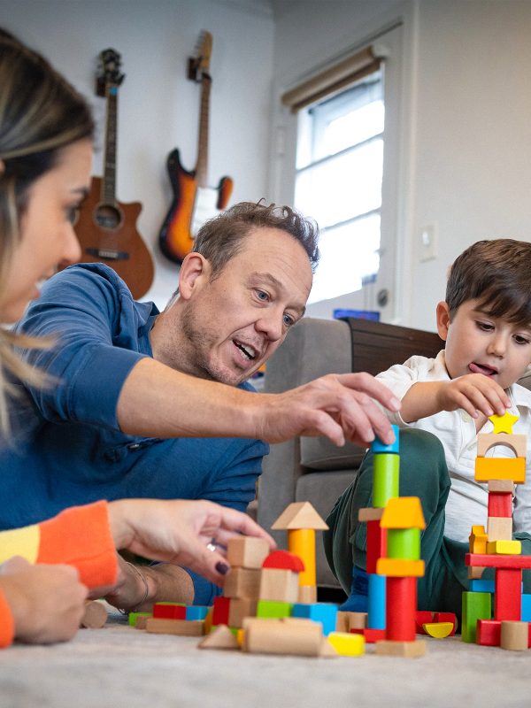 FAMILY COMMUNITYMum and dad playing with their young son approx. 5 using building blocks