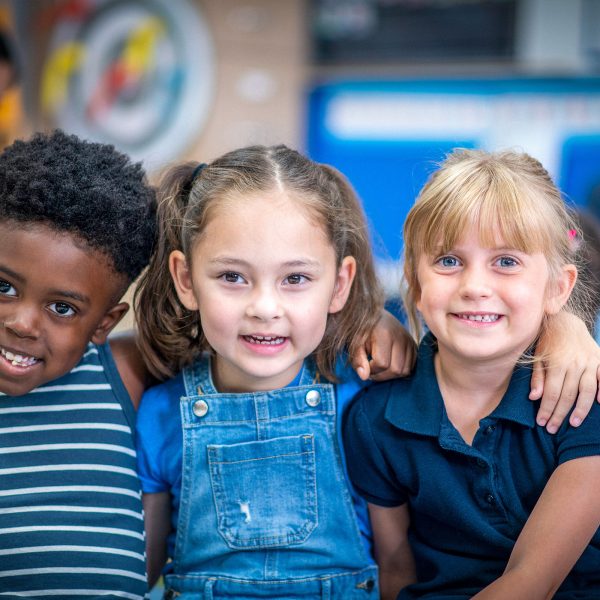 Three young multicultural foster kids smiling looking at the camera