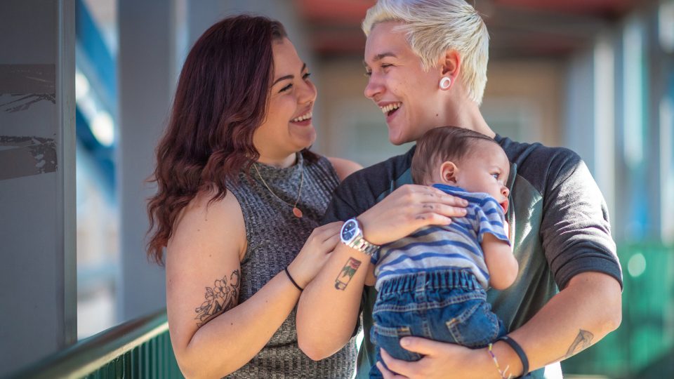 Same sex young female couple foster carers looking after an infant