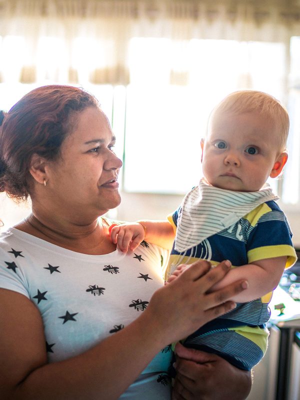 KINSHIP CARE auntie holding her infant nephew with caring look in her eyes who she is looking after for her sister