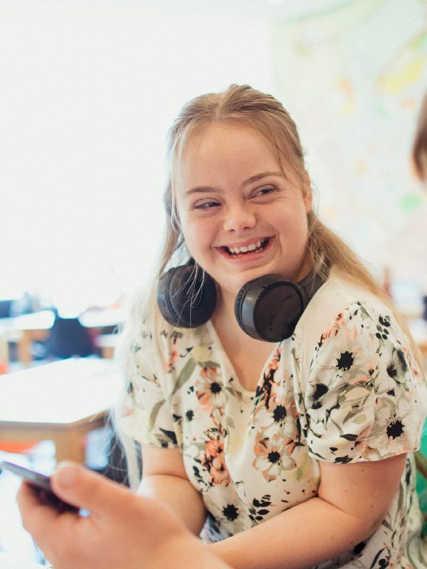 DISABILITY young adult female with Downs syndrome chatting with her male friend in a cafe over lunch