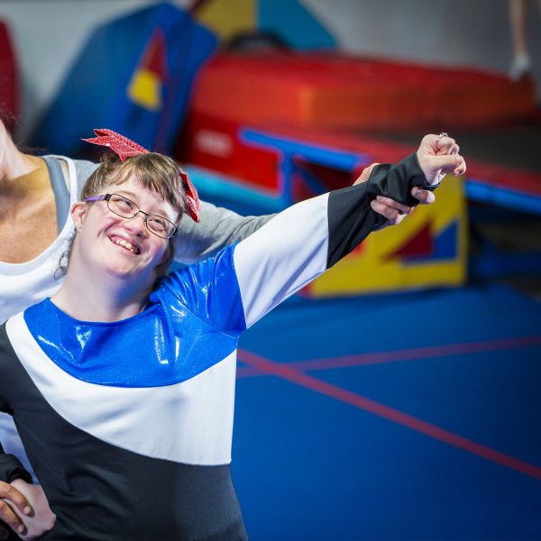 DISABILITY woman teaching a teenage girl with Downs syndrome gymnastic moves