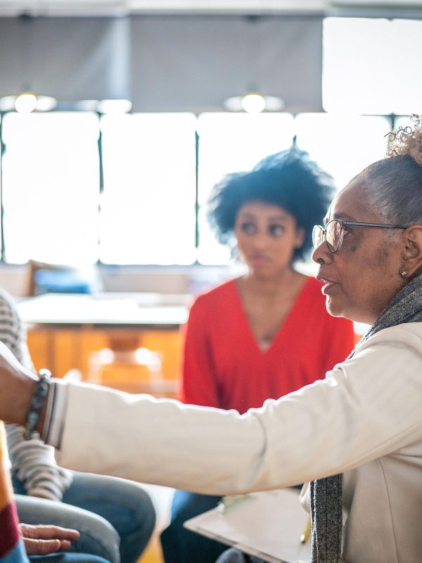 MENTAL HEALTH Woman leading the Horizons group therapy compassion with hand on shoulder of an older male as she listens intently