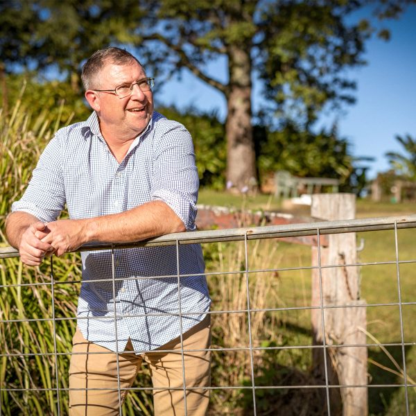 MENTAL HEALTH older adult male in rural Tasmania on farm looking thoughtful as he leans on a gate