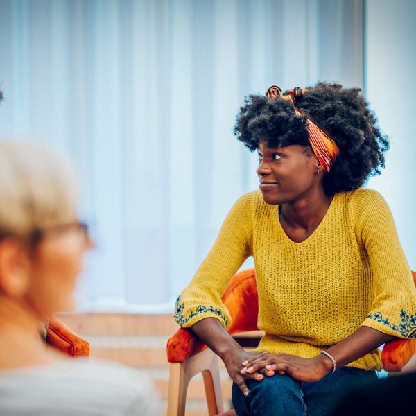 MENTAL HEALTH young adult female in Horizons group therapy chatting with another group member