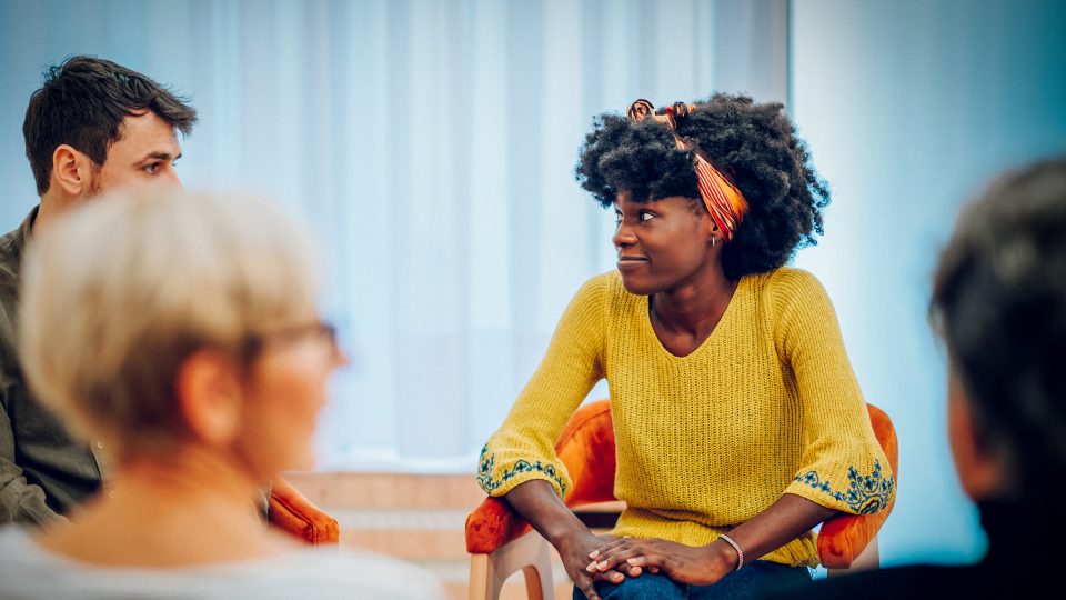 MENTAL HEALTH young adult female in Horizons group therapy chatting with another group member