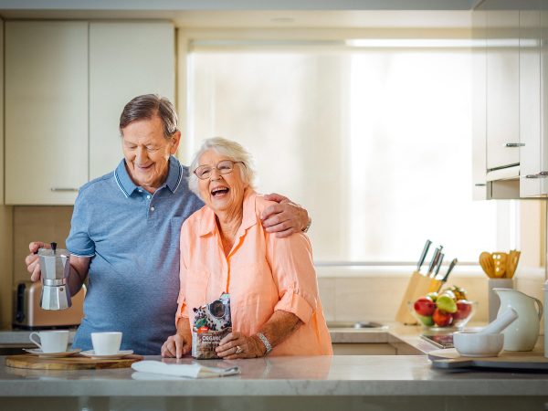 Enjoying the kitchen, coffee and a laugh at their apartment at Karana Retirement Living