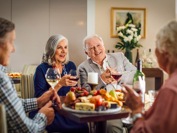 Enjoying a glass of wine and meal in the community hub at Karana Retirement Living