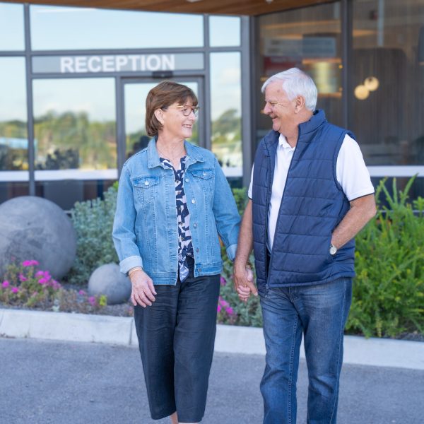 Retirement Living residents outside TheOrchards hub smiling as they walk