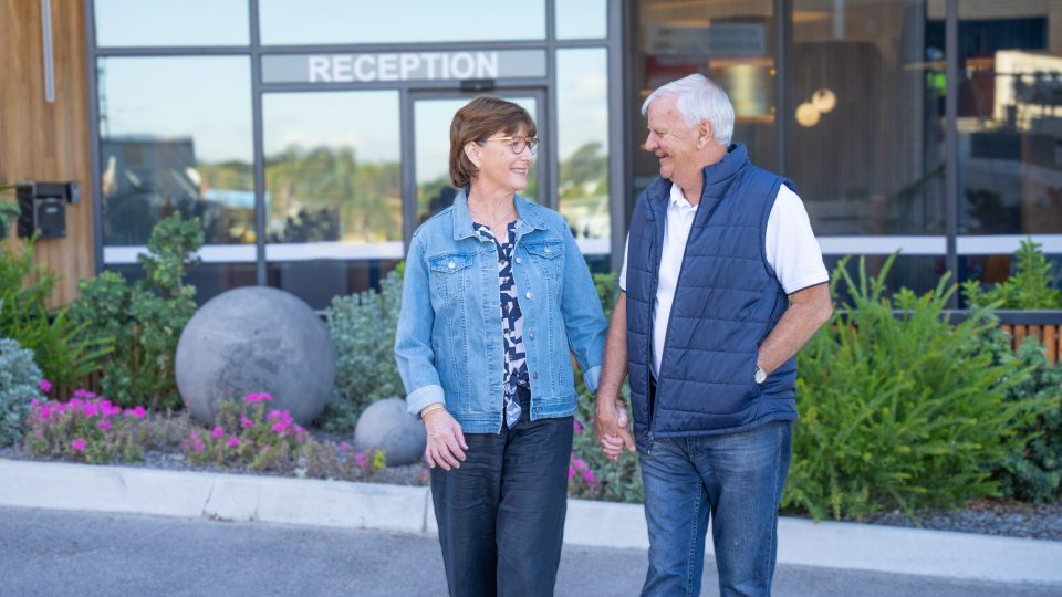 Retirement Living residents outside TheOrchards hub smiling as they walk