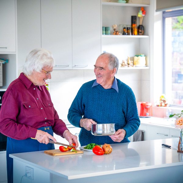 Residents in kitchen of their villa at Karingal Retirement Living cutting up vegetables