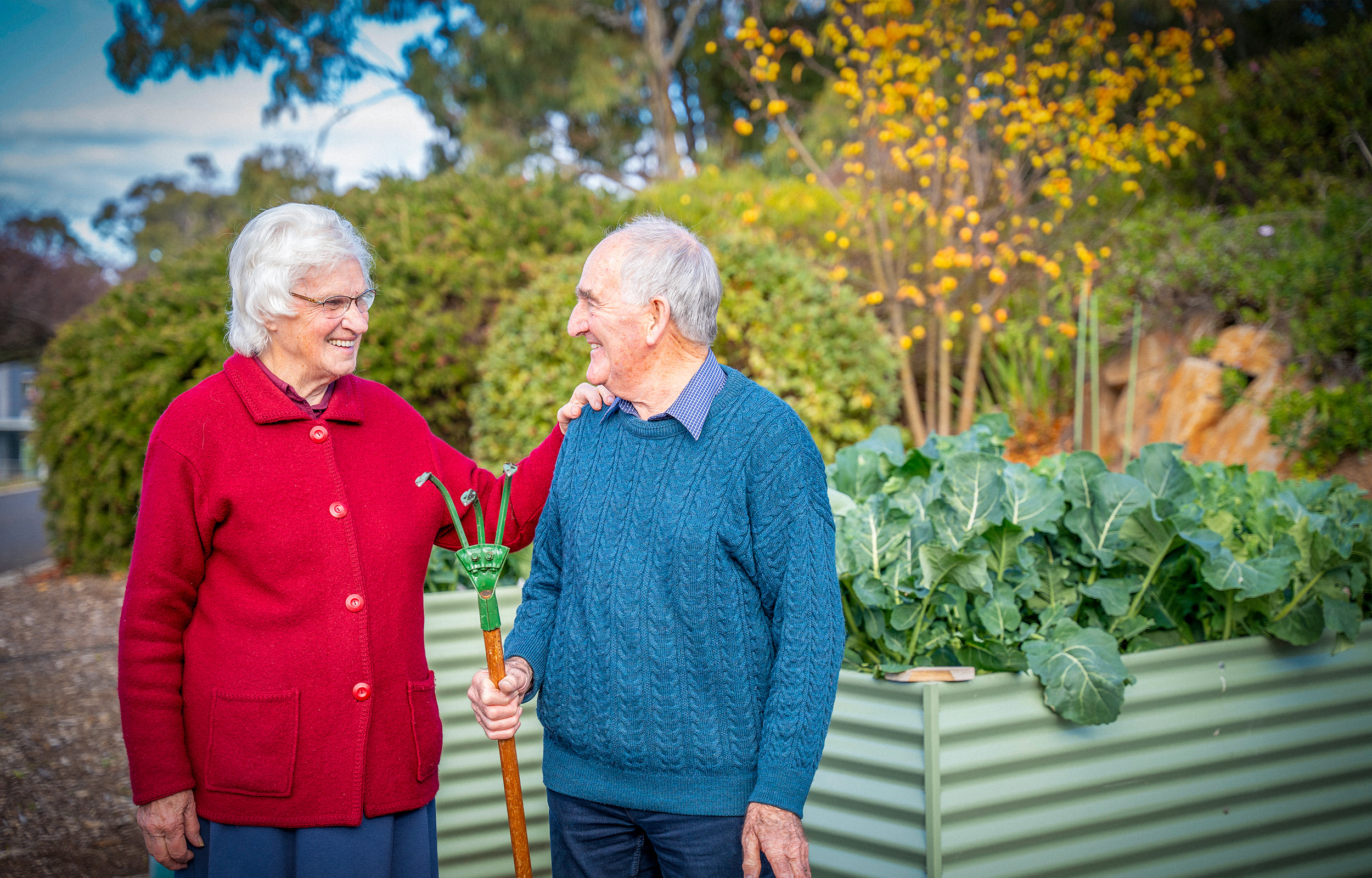 Residents in garden of their villa at Karingal Retirement Living tending to vegetables