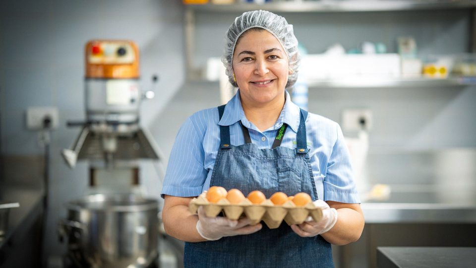 CAREERS Food assistant portrait with eggs in a residential aged care home wearing hair net