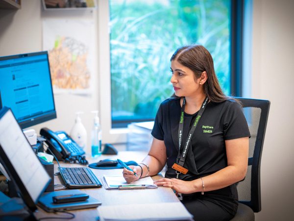 CAREERS Nursing coordinator organising roster at the nurses station in a residential aged care home