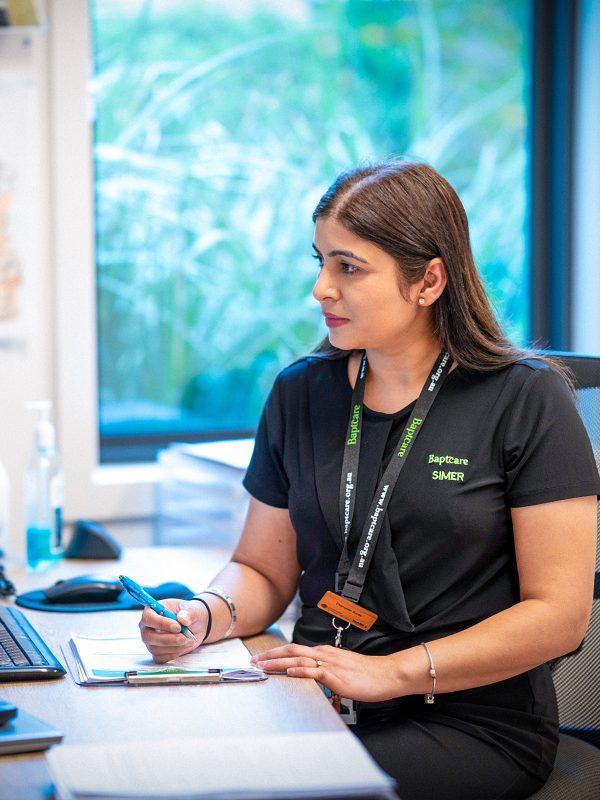 CAREERS Nursing coordinator organising roster at the nurses station in a residential aged care home