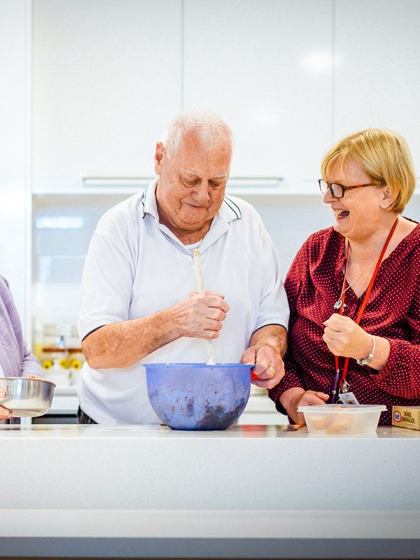 BAPTCARE THE ORCHARDS Resident, wife and staff member enjoying a cooking activity