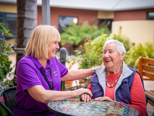 BAPTCARE KARINGAL Resident with staff member outside in courtyard sharing a smile