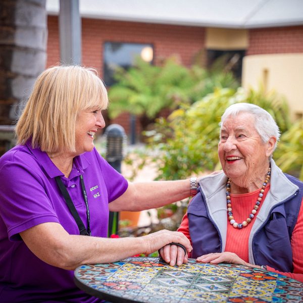 BAPTCARE KARINGAL Resident with staff member outside in courtyard sharing a smile