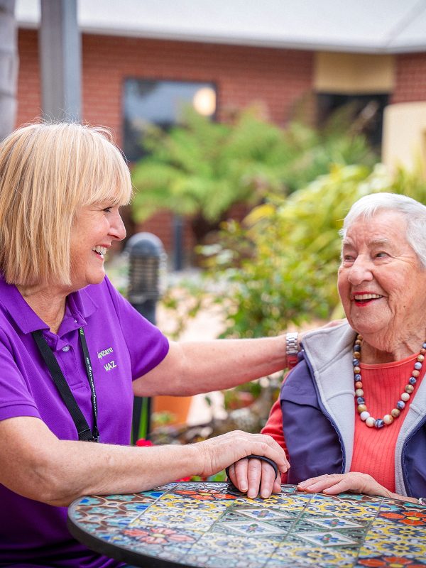 BAPTCARE KARINGAL Resident with staff member outside in courtyard sharing a smile