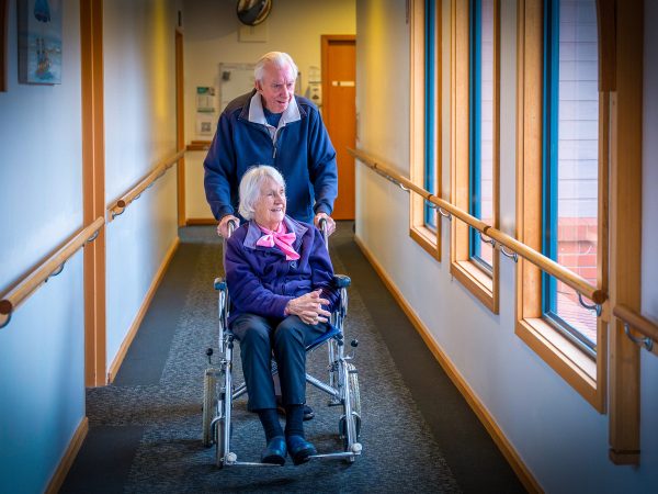 BAPTCARE KARINGAL Resident couple strolling through a corridor with a view to outside