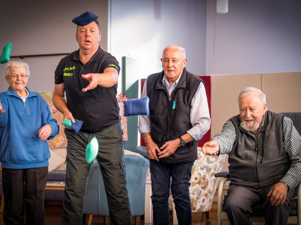 HOME CARE staff member playing a Bean Bag Bucket game with Home Care Package customers at Orana Social Activities and Respite Centre