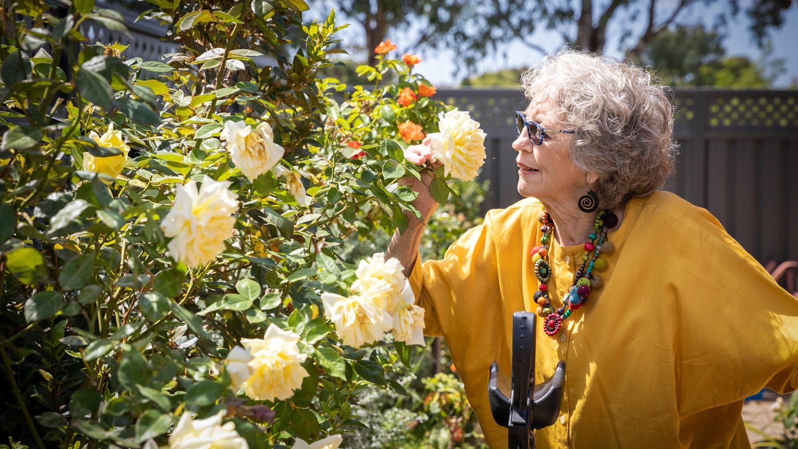 HOME CARE Lynette a Home Care Package customer with BaptistCare at home in the garden smelling the roses