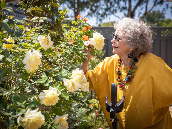 HOME CARE Lynette a Home Care Package customer with BaptistCare at home in the garden smelling the roses