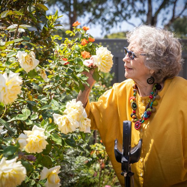 HOME CARE Lynette a Home Care Package customer with Baptcare at home in the garden smelling the roses
