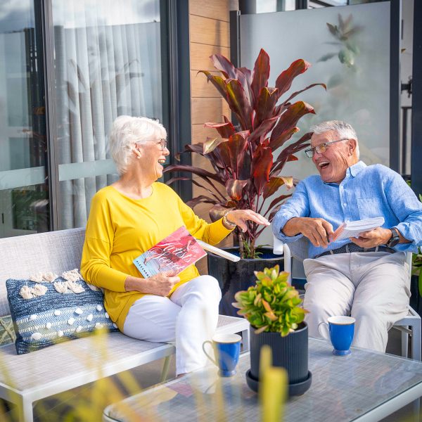 Residents at Peninsula View apartments enjoying their outdoor balcony and having a laugh