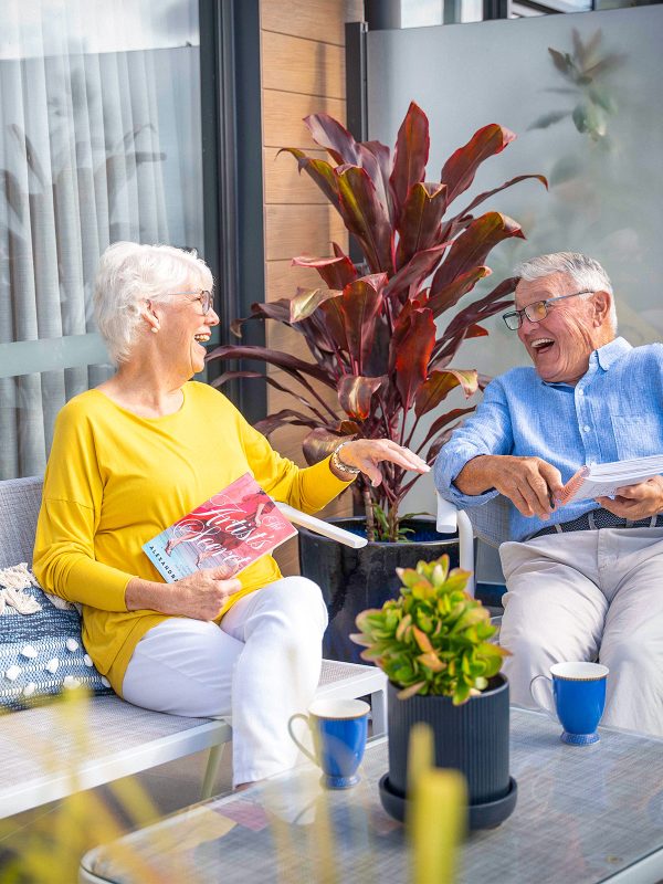 Residents at Peninsula View apartments enjoying their outdoor balcony and having a laugh