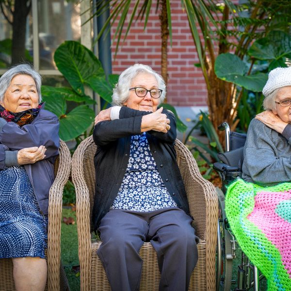 BAPTCARE WESTHAVEN three residents smiling doing stretching exercises in chairs