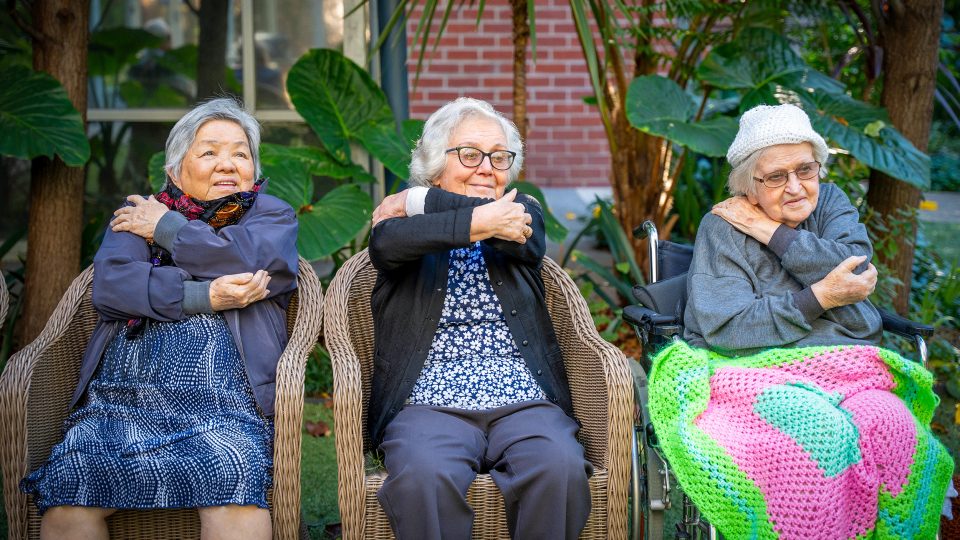 BAPTCARE WESTHAVEN three residents smiling doing stretching exercises in chairs