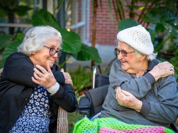 BAPTCARE WESTHAVEN two residents smiling doing stretching exercises in chairs