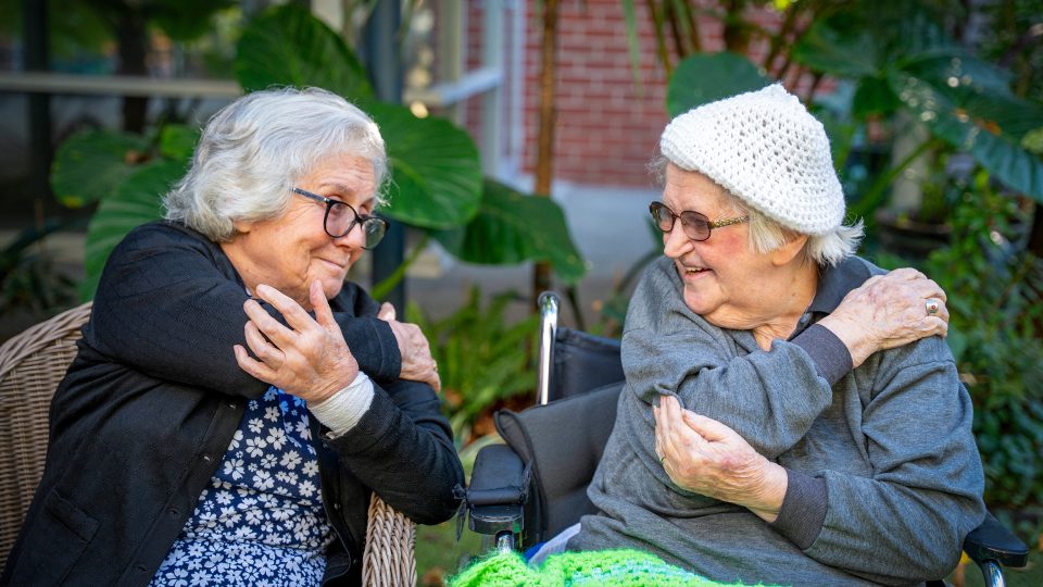 BAPTCARE WESTHAVEN two residents smiling doing stretching exercises in chairs