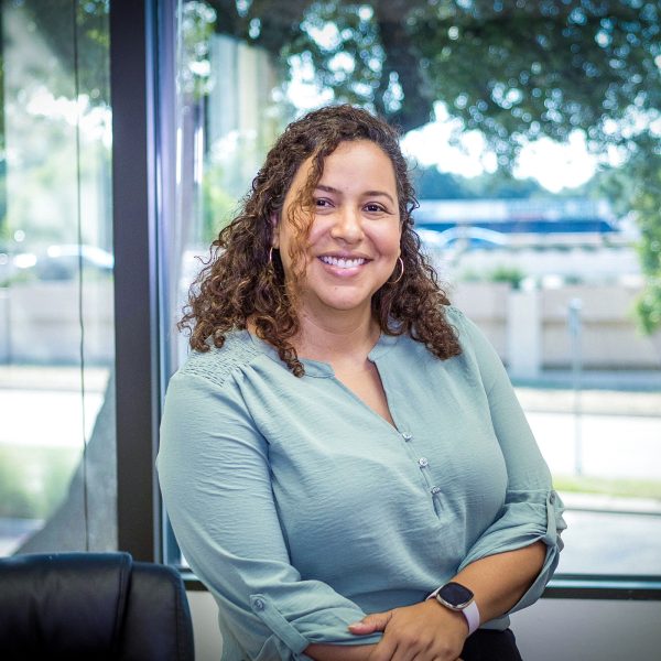 Smiling female staff member with reassuring smile ready to answer your calls